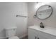 Modern bathroom featuring a sleek round mirror, white vanity, and updated fixtures at 733 W El Prado Rd, Chandler, AZ 85225