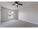 Carpeted bedroom featuring a ceiling fan and natural light through a large window at 733 W El Prado Rd, Chandler, AZ 85225