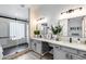 Bright bathroom with double sinks, quartz counters, and a glass-enclosed shower at 8449 W Rockwood Dr, Peoria, AZ 85382