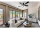Sun room with tile flooring, a white sofa, and large sliding glass windows at 8449 W Rockwood Dr, Peoria, AZ 85382