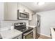 Updated kitchen with stainless steel appliances, light grey cabinets, and a sleek subway tile backsplash at 8538 E Portland St, Scottsdale, AZ 85257