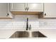 Close-up of kitchen sink area with stainless steel sink, and white subway tile backsplash at 8538 E Portland St, Scottsdale, AZ 85257