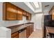 Kitchen featuring wood cabinets, stainless steel appliances, tile backsplash, and a skylight at 8552 E Indian School Rd # B, Scottsdale, AZ 85251