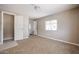 A carpeted bedroom features a light-filled window and a door to other rooms at 8600 E Broadway Rd # 53, Mesa, AZ 85208