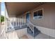 Exterior shot of a shaded front porch with stairs leading to a blue front door at 8600 E Broadway Rd # 53, Mesa, AZ 85208