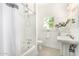 Clean bathroom with a classic tub-shower, pedestal sink, and black-and-white tile floor at 917 W Willetta St, Phoenix, AZ 85007