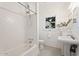 Clean and bright bathroom featuring a classic tub, pedestal sink, and a window at 917 W Willetta St, Phoenix, AZ 85007