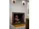 Stacked wood in a brick fireplace beneath sconces offers rustic charm at 917 W Willetta St, Phoenix, AZ 85007