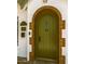 Close-up of a charming green front door with brick archway and vintage details at 917 W Willetta St, Phoenix, AZ 85007