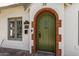 Close-up of a charming green front door with brick archway and vintage details at 917 W Willetta St, Phoenix, AZ 85007