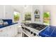 Bright kitchen with stainless steel range, blue tile counters, breakfast nook, and view of the backyard at 917 W Willetta St, Phoenix, AZ 85007