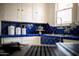 Charming kitchen featuring beautiful blue tile countertops, white cabinets, and natural light from the window above the sink at 917 W Willetta St, Phoenix, AZ 85007