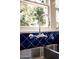 Close-up of a kitchen sink with blue tile backsplash and chrome faucet at 917 W Willetta St, Phoenix, AZ 85007