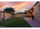 Backyard with artificial turf, brick patio, a built-in grill, and ambient string lights at 9831 E Tupelo Ave, Mesa, AZ 85212
