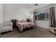A cozy bedroom with a double bed, crib, neutral color tones, and natural light from the window at 9831 E Tupelo Ave, Mesa, AZ 85212