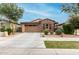 Attractive single-story home featuring brick accents, a two-car garage, and easy-care desert landscaping at 9831 E Tupelo Ave, Mesa, AZ 85212