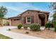 Inviting single-story home features a two-car garage, brick facade, and low-maintenance desert landscaping at 9831 E Tupelo Ave, Mesa, AZ 85212