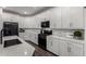 This kitchen boasts white cabinets, stone countertops, stainless steel appliances and plank flooring at 9831 E Tupelo Ave, Mesa, AZ 85212