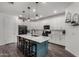 Bright kitchen featuring a blue island, white cabinets, modern appliances, and elegant pendant lighting at 9831 E Tupelo Ave, Mesa, AZ 85212