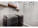 Laundry room featuring modern gray front load washer and dryer units, with overhead cabinets at 9831 E Tupelo Ave, Mesa, AZ 85212