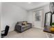 A quaint room has a loveseat near a bright window with sheer curtains at 9831 E Tupelo Ave, Mesa, AZ 85212