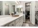 Bathroom featuring double sinks, a large mirror, and a door leading to a walk-in closet at 10310 E Tillman Ave, Mesa, AZ 85212