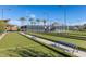 Bocce ball court with benches under a clear sky, surrounded by lush landscaping with palm trees in a resort-style setting at 10310 E Tillman Ave, Mesa, AZ 85212