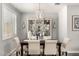 Formal dining room featuring stylish chandelier, elegant furniture, and ample natural light with plantation shutters at 10310 E Tillman Ave, Mesa, AZ 85212