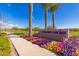 Welcome to the Encore Center, featuring landscaped entrance with colorful flowers and palm trees under a bright, clear sky at 10310 E Tillman Ave, Mesa, AZ 85212