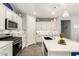 View of the kitchen with stainless steel appliances, white cabinets, and a large kitchen island at 10310 E Tillman Ave, Mesa, AZ 85212