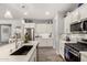 Bright kitchen boasts white cabinets, stainless steel appliances, and a large island with a dark sink at 10310 E Tillman Ave, Mesa, AZ 85212