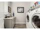 Well-equipped laundry room with a sink, cabinets, and modern washer/dryer units at 10310 E Tillman Ave, Mesa, AZ 85212