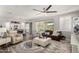 Open-concept living room featuring neutral tones, stylish furniture, and large windows with backyard views at 10310 E Tillman Ave, Mesa, AZ 85212