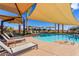 Relaxing pool area with chaise lounges and shade covers, surrounded by lush landscaping, perfect for enjoying sunny days at 10310 E Tillman Ave, Mesa, AZ 85212