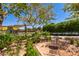 Charming outdoor seating area with a metal table and chairs surrounded by lush greenery and views of the putting green at 10310 E Tillman Ave, Mesa, AZ 85212
