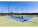 Well-maintained tennis courts featuring blue and green surfaces, surrounded by tall fencing and bright overhead lighting at 10310 E Tillman Ave, Mesa, AZ 85212