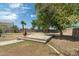 Backyard featuring mature shade trees, a decorative fire pit, and a stone patio with brick accents at 1106 E Altadonna St, San Tan Valley, AZ 85140