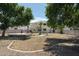 Expansive backyard with mature trees, block fencing, a brick perimeter, and a patio area, offering outdoor living at 1106 E Altadonna St, San Tan Valley, AZ 85140