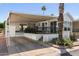 Charming home exterior featuring a covered patio, carport, and mature desert landscaping at 111 S Greenfield Rd # 190, Mesa, AZ 85206