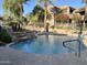 Beautiful community pool with rock waterfall feature, surrounded by lush landscaping and palm trees at 11680 E Sahuaro Dr # 2011, Scottsdale, AZ 85259