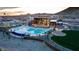 Aerial view of a community pool and clubhouse, featuring ample seating and mountain views at sunset at 11940 W Calle De Pompas --, Peoria, AZ 85383