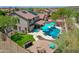 Aerial view of this backyard featuring a pool, lawn, firepit, and outdoor cooking area, ideal for outdoor living at 12706 W Pasaro Dr, Peoria, AZ 85383
