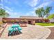 Outdoor kitchen with a fire pit, seating, artificial turf, and a picnic table at 12706 W Pasaro Dr, Peoria, AZ 85383