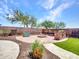 Landscaped backyard with a fire pit, seating, and decorative walls at 12706 W Pasaro Dr, Peoria, AZ 85383