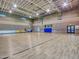 Spacious indoor basketball court featuring a hardwood floor, brick walls, and ample lighting at 12706 W Pasaro Dr, Peoria, AZ 85383