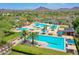 Aerial view of a resort-style community pool featuring palm trees, cabanas, and mountain views at 12706 W Pasaro Dr, Peoria, AZ 85383