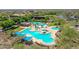 Aerial view of a resort-style pool area with multiple pools, cabanas, and lush greenery at 12706 W Pasaro Dr, Peoria, AZ 85383