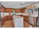 A well-lit kitchen features an island, stainless appliances, granite countertops, and custom cabinets for ample storage space at 12706 W Pasaro Dr, Peoria, AZ 85383