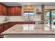 A modern kitchen features granite countertops, stainless steel appliances, and access to a backyard pool area at 12706 W Pasaro Dr, Peoria, AZ 85383