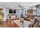 A spacious living room boasts hardwood floors, a ceiling fan, and a comfortable sectional sofa at 12706 W Pasaro Dr, Peoria, AZ 85383